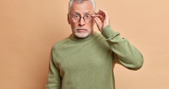 senior man stares through glasses