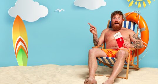 topless bearded redhead man posing on beach
