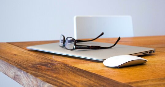 Laptop mit Brille auf dem Tisch