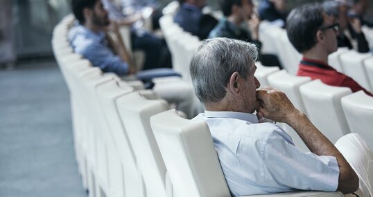 Konferenzsaal mit drei sichtbaren Reihen