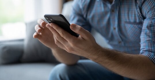 Hands of man using online virtual app on mobile phone. Millennial guy chatting on smartphone, using banking services, reading text message, typing, shopping, making call, browsing internet. Close up