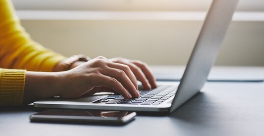 Close up of female hands while typing on laptop