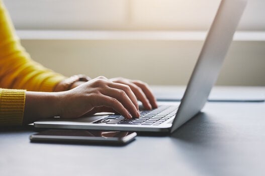 Close up of female hands while typing on laptop