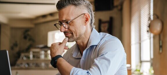 European grey man working with papers and laptop at office