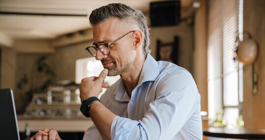 European grey man working with papers and laptop at office