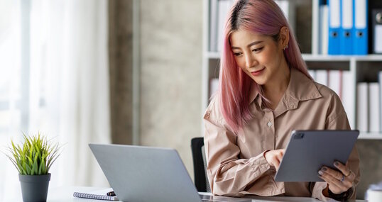 Portrait of a young Asian businesswoman working on a tablet with a laptop at the thinking office. analyze marketing data online business ideas.