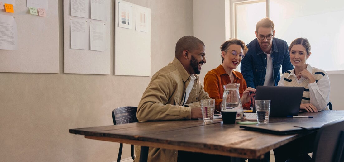 Cheerful business colleagues watching a presentation on a laptop