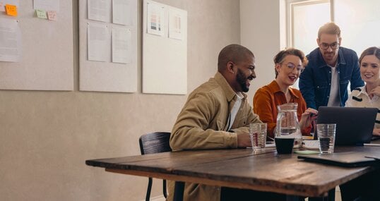 Cheerful business colleagues watching a presentation on a laptop