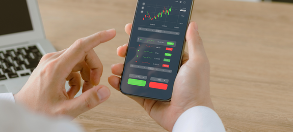 Businessmen work with stock market investments using smartphones to analyze trading data. smartphone with stock exchange graph on screen. Financial stock market