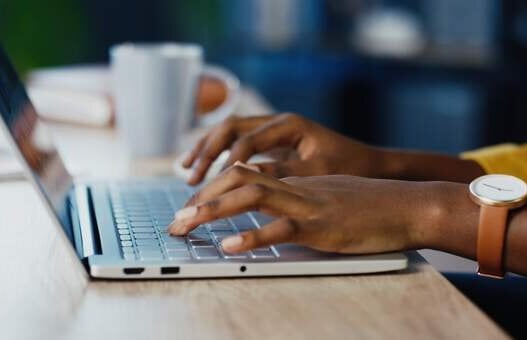 Close up shot of female hands typing on laptop