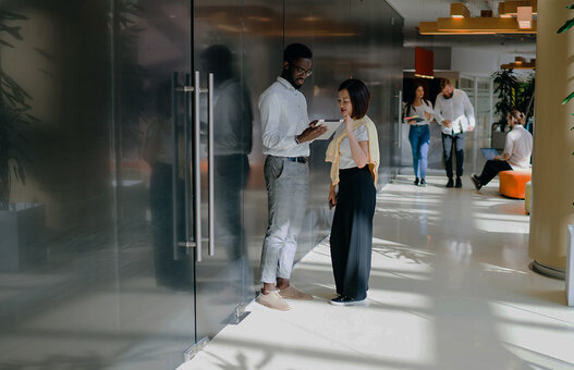 Diverse people in spacious office while discussing work questions