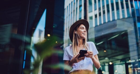 Cheerful woman listening to music in cafe