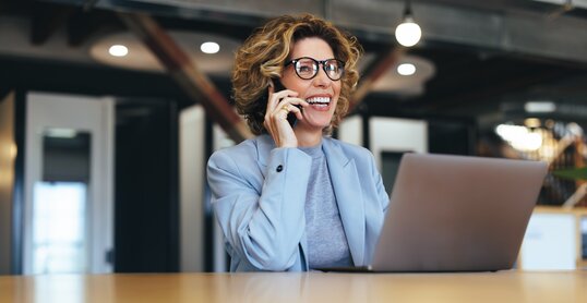 Business woman talking on a phone call in a coworking office