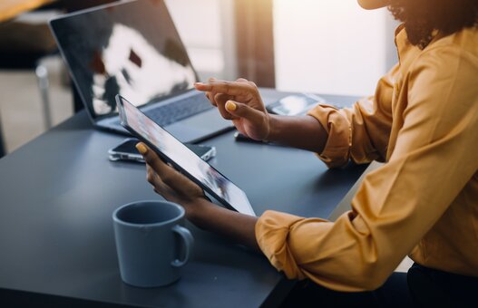 Portrait of Young Asian woman hand freelancer is working her job on computer tablet in modern office. Doing accounting analysis report real estate investment data, Financial and tax systems concept.