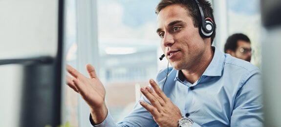 Businessman, call center and consulting on computer in customer support, service or telemarketing at office. Man employee, consultant or agent talking on PC for online advice or help in contact us