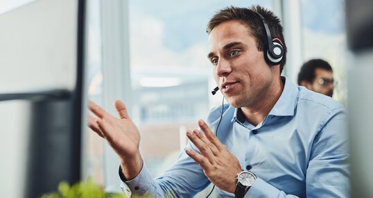 Businessman, call center and consulting on computer in customer support, service or telemarketing at office. Man employee, consultant or agent talking on PC for online advice or help in contact us