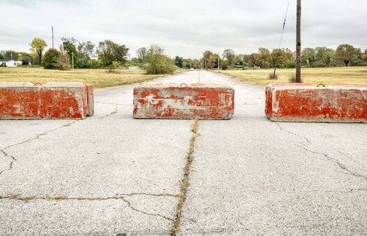 Rote Zementblöcke, die auf einer Straße eine Barriere bilden.