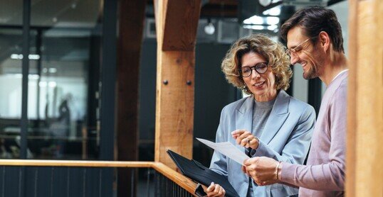 Business people analysing a financial report together. Two business people discussing in an office