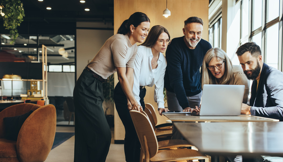 Group of businesspeople using a laptop together