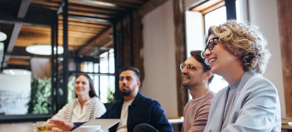 Conference meeting in an office, happy business team sits together in a boardroom