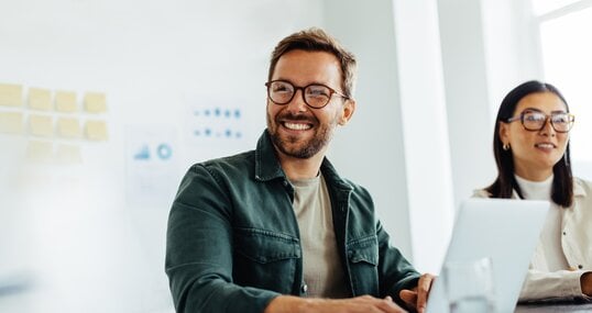 Happy business man listening to a discussion in an office