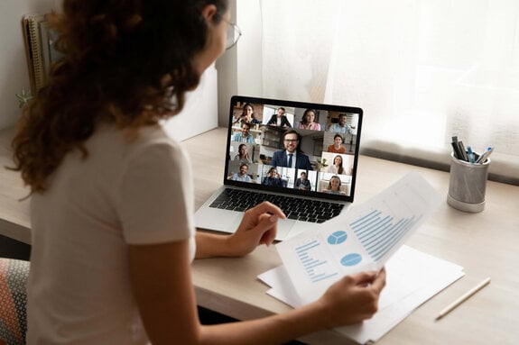 Foto einer Frau die auf einem Laptop schaut auf dem ein Video Call stattfindet