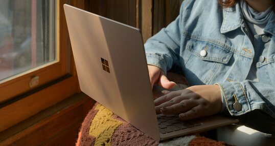 Eine Frau, die mit einem Laptop auf einem Stuhl sitzt