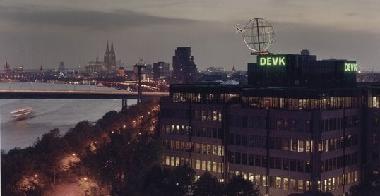 Foto der Firmenzentrale der DEVK mit Kölner Skyline im Hintergrund im Abendlicht