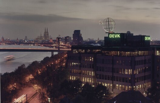 Foto der Firmenzentrale der DEVK mit Kölner Skyline im Hintergrund im Abendlicht