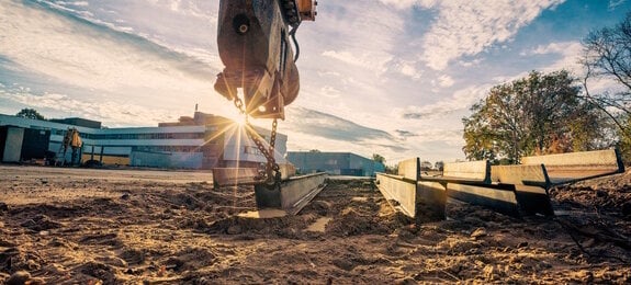 Bagger auf Baustelle bei Sonnenaufgang